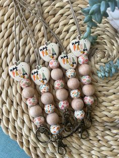 several wooden beads are sitting on a wicker basket next to some flowers and plants