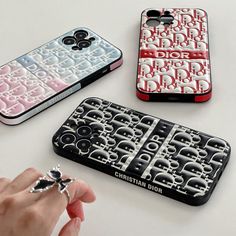 three cell phones with different designs on them, one is red and the other is white