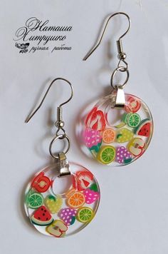 a pair of earrings with fruit designs on them