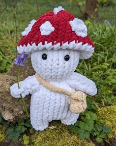 a crocheted stuffed animal wearing a red and white knitted hat with flowers