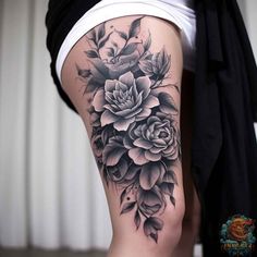 a woman's thigh with black and white flowers on the side, in front of her