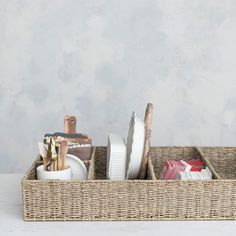 a wicker basket with dishes and utensils in it