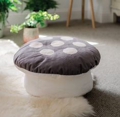 a white and brown polka dot cushion on the floor