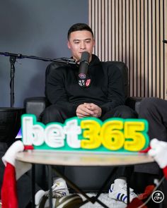 a man sitting in front of a cake with the words bett365 on it