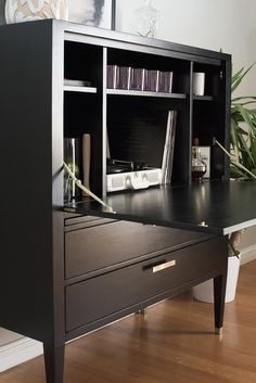 a black desk with drawers and books on it