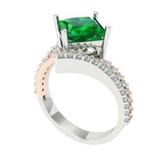 an emerald and diamond ring on a white background