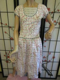 Vintage 50s untagged cotton hourglass dress with a white background and pink grid design with a roses print. Has a low scoop neck with ruffled tiers that are edged in black, black and white ribbon trim, back metal zipper, belt loops-no belt. Also see our other great items including more dresses, we gladly combine shipping. Buyer pays in three days, pays shipping. Very good vintage condition. Measurements- Chest-32" Waist-25" Hips-basically free Overall length-43 1/2" Sweep-70" Vintage 50s untagg Spring Rockabilly Dress With Short Sleeves, Pink Fitted Casual Vintage Dress, Spring Cotton Rockabilly Dresses, Fitted Retro Rose Print Dresses, Retro Fitted Dress With Rose Print, Vintage Ruffled Dress For Tea Party, Vintage Dress With Ruffles For Tea Party, Pink Fitted Rockabilly Dress, Pink Retro Cotton Vintage Dress