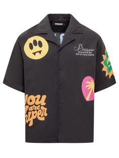 a black shirt with patches on the chest and an embellished smiley face in front