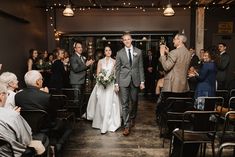 a bride and groom walking down the aisle