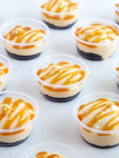 there are many desserts in small plastic cups on the table, ready to be eaten