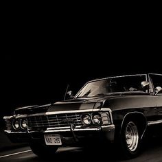 a black and white photo of a classic car