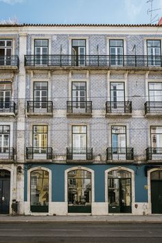 an old building with many windows and balconies on the top floor is painted blue