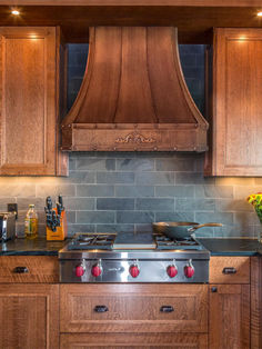 a stove top oven sitting inside of a kitchen next to wooden cabinets and counter tops