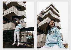 a woman wearing a blue sweatshirt and white pants standing in front of a tall building