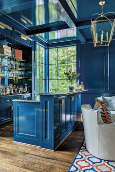 a living room with blue walls and wood flooring in the center is a bar