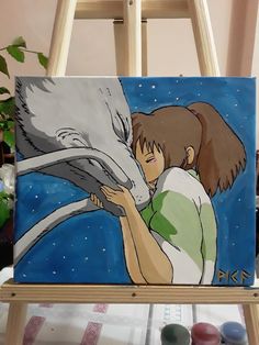 a painting of a girl hugging a horse on a easel next to paintbrushes