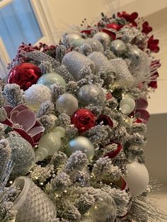 a christmas tree decorated with silver, red and white ornaments