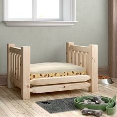 a dog bed in the corner of a room with a cat bowl on the floor