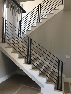 a white staircase with black railing and handrail