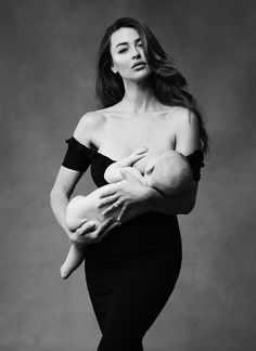 a black and white photo of a woman holding a baby