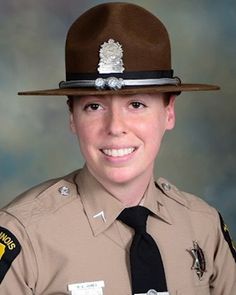 a female police officer in uniform posing for a photo with her name tag on her hat