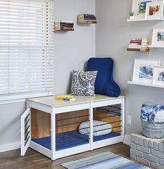 a blue chair sitting on top of a wooden shelf next to a window filled with books