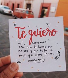 a hand holding up a piece of paper that says te quiero ques