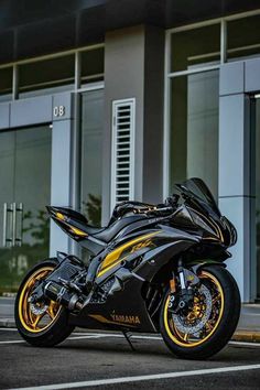 a black and yellow motorcycle parked in front of a building