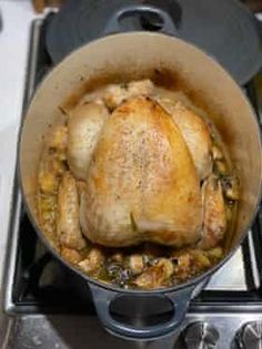 a chicken is cooking in a pot on the stove