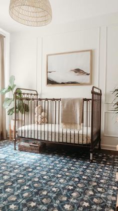 a baby crib in the corner of a room with a rug on the floor