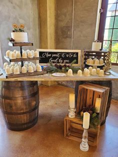 a table topped with lots of cupcakes next to a barrel