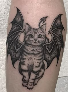 a cat with a bat tattoo on it's leg