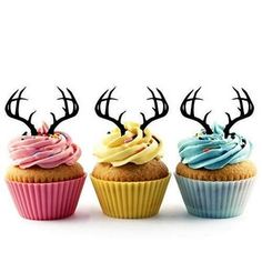 three cupcakes with colorful frosting and antlers on top are lined up next to each other