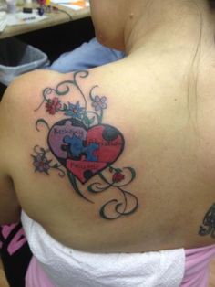 a woman with a heart shaped puzzle tattoo on her shoulder