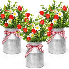 two tin cans filled with flowers and daisies