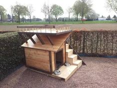 a dog house built into the side of a hedge