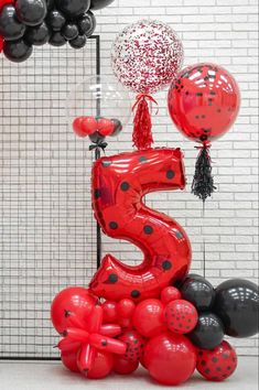 the number five balloon is surrounded by black and red balloons