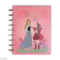 a pink notebook with an image of princesses on the cover and text never stop dreaming