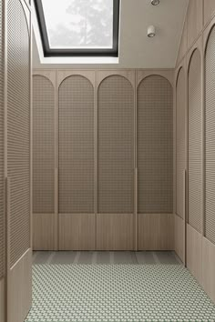 an empty room with several wooden lockers and skylight in the ceiling above it