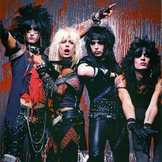 four women dressed in punk clothing posing for the camera