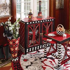 a red and black table sitting on top of a rug