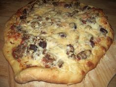 a pizza sitting on top of a wooden cutting board