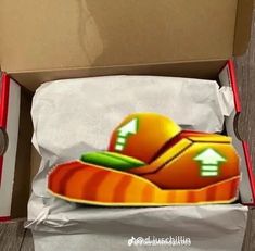 an orange shoe is in a box on the floor