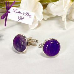 These beautiful cufflinks feature polished natural raw Amethyst cabochons and are perfect for a Father's Day Gift. Set in silver plated settings. Approximate diameter 16mm. Maybe add a match Amethyst Key Ring or Key Fob for something a bit extra... These cabochons are natural products so each amethyst cufflinks set will be unique and variations will occur. Boxed in a luxury box with magnetic closure. All of our jewellery boxes are eco friendly and FSC certified. See our complete range of Amethys Amethyst Cufflinks, Wedding Cuff Links, Wedding Cuff, Raw Amethyst, Eco Friendly Packaging, Amethyst Gem, Cufflink Set, Cufflinks Wedding, Luxury Boxes