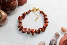 This Red Jasper gemstone chip bracelet is made with care and attention to detail using gorgeous tumbled Red Jasper chips arranged in a graduated size design for an attractive look. The Jasper is interspersed with 2mm gold filled beads. The bracelet is 18 cm long and is fastened using a gold plated lobster claw clasp and 25mm extension chain for an adjustable fit. The bracelet is constructed using  19 strand beading wire making it both flexible yet very strong. Red Japer is widely regarded as an Gemstone Chips Bracelet, Semi Precious Stone Bracelet, Chip Bracelet, Earthy Jewelry, Crystal Healing Bracelets, Unisex Gift, Citrine Crystal, Lava Bead, Beading Wire