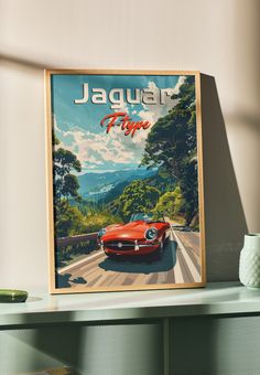 a red car driving down the road in front of a sign that says jaguar time