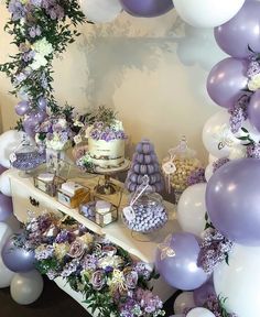 a dessert table with purple and white balloons