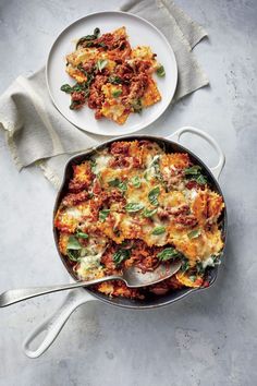 two pans filled with lasagna casserole on top of a table