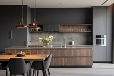 a modern kitchen with wooden cabinets and gray walls