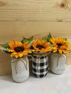 three mason jars with sunflowers in them